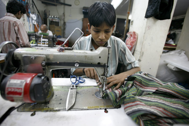 Un enfant travaillant dans un atelier textile à Delhi. Février 2008, Inde. 